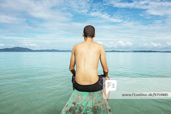 Philippinen  Palawan  El Nido  Mann am Bug eines Bootes sitzend