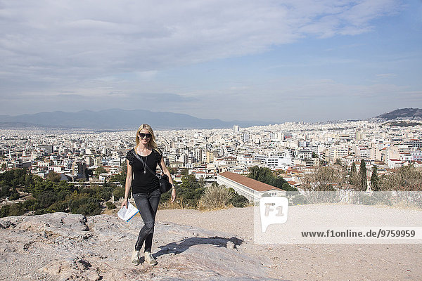 Greece  Athens  view to city from acropolis with female tourist in the foreground