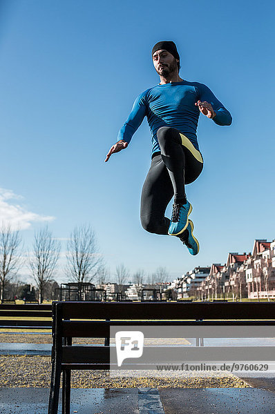 Spain  Gijon  athlete jumping over park bench