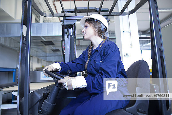 Worker in factory hall on forklift