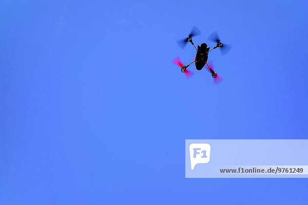 Fliegende Mini-Drohne vor blauem Himmel