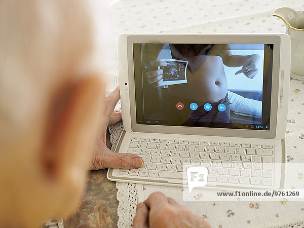 Großvater-Videokonferenz mit schwangerer Enkelin über digitales Tablett