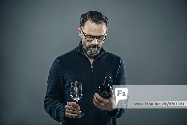 Mann mit Rotweinglas und Weinflasche
