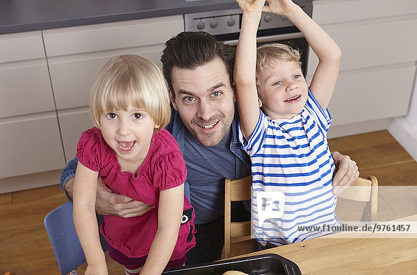 Father and happy kids in kitchen
