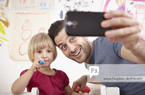 Vater und Tochter nehmen Selfie mit Smartphone