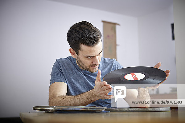 Man sitting at table with old vinyl records
