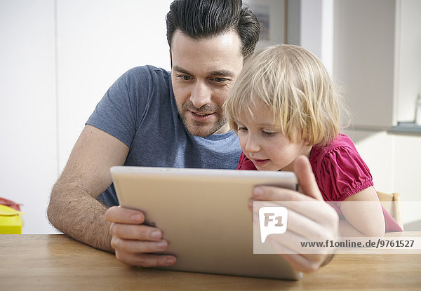 Father and little daughter using digital tablet