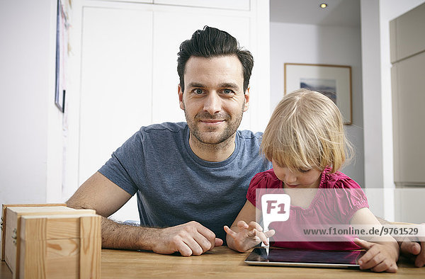 Father and little daughter using digital tablet