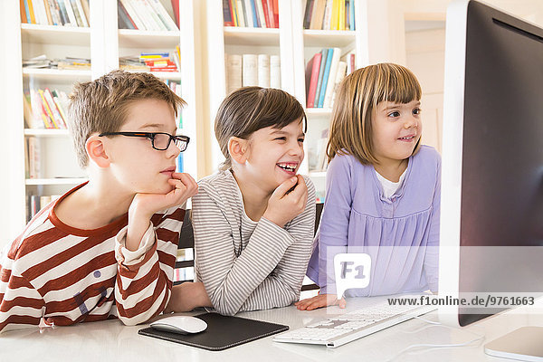 Der Junge und seine beiden Schwestern verbringen Zeit am Computer.