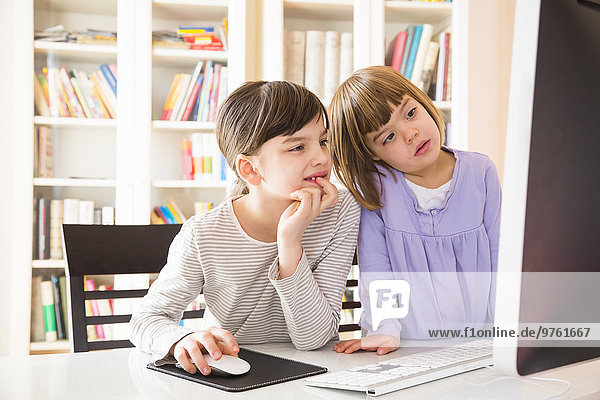 Two sisters spending time together at computer