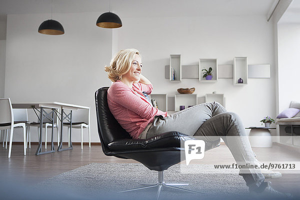 Woman relaxing on leather chair at home