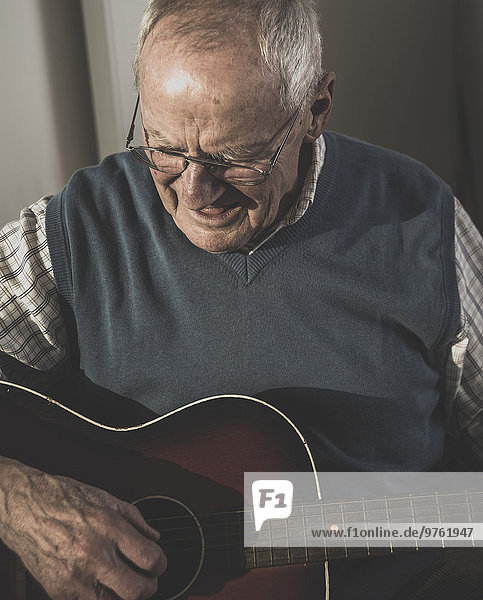 Senior Mann spielt Gitarre