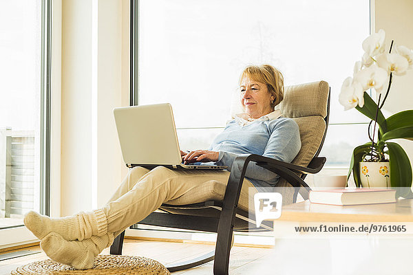 Senior woman at home using laptop