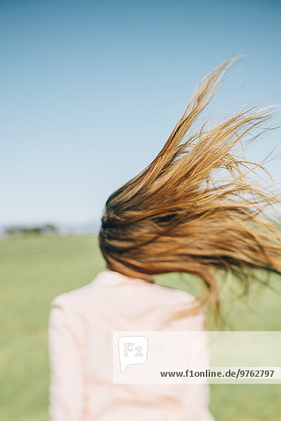 Wind bewegt lange Haare einer Frau