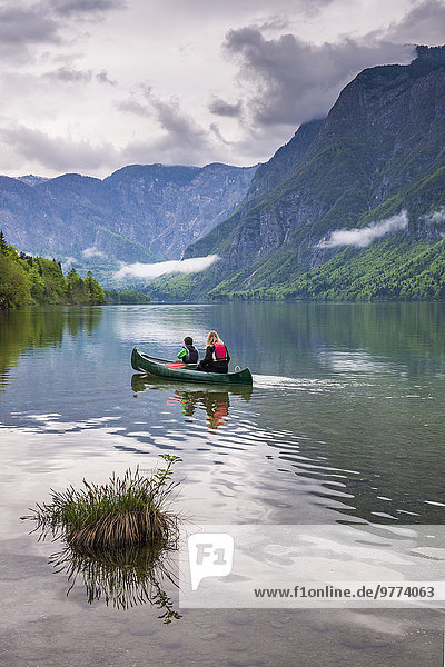 Mother and son canoeing on Lake Bohinj  Triglav National Park  Julian Alps  Slovenia  Europe