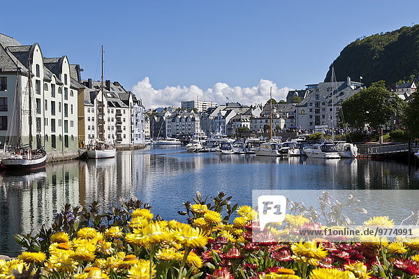 Boats and Art Nouveau buildings with waterside summer flowers  Alesund  More og Romsdal  Norway  Scandinavia  Europe
