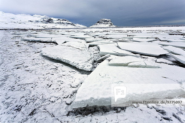 Winter view over slabs of broken lake ice covered in snow towards Kirkjufell (Church Mountain)  near Grundarfjordur  Snaefellsnes Peninsula  Iceland  Polar Regions