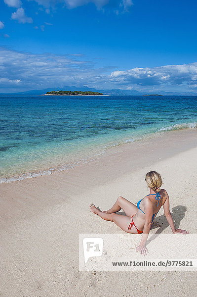 sitzend Frau Strand weiß Sand Insel Pazifischer Ozean Pazifik Stiller Ozean Großer Ozean Fiji