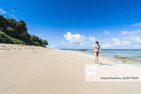 Woman walking on a white sand beach on a little islet in Haapai  Haapai Islands  Tonga  South Pacific  Pacific