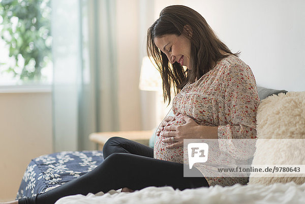 sitzend Frau Bett Schwangerschaft
