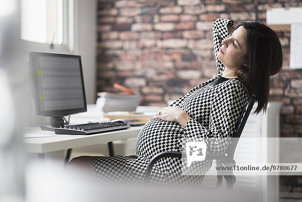 Pregnant woman relaxing in office