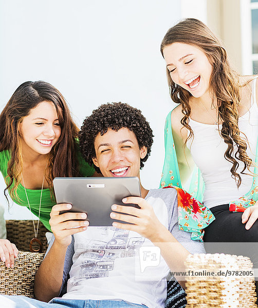 Group of friends (14-15) using digital tablet
