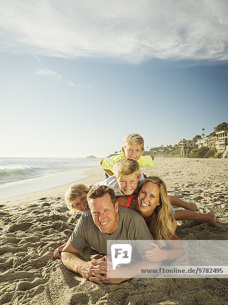 Portrait of smiling family with children (6-7  10-11  14-15) on beach