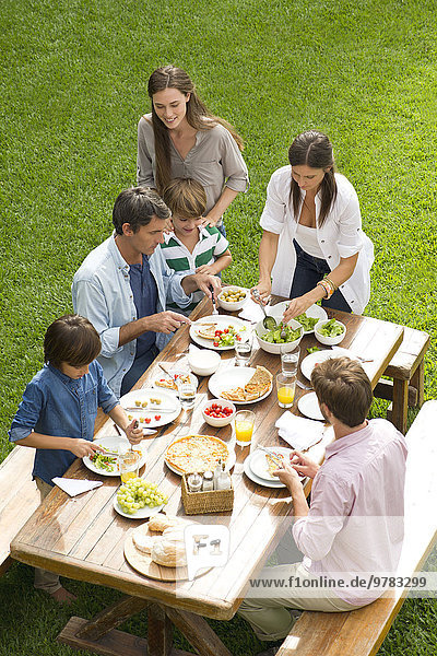 Familie und Freunde genießen gesundes Essen im Freien