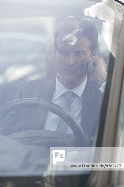 Geschäftsmann beim Telefonieren während der Fahrt