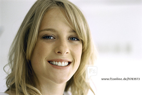 Blonde teenage girl smiling at camera  portrait