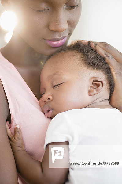 Black mother holding sleeping son