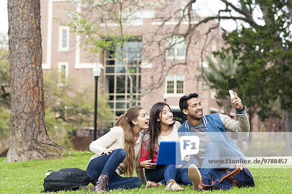 Students taking cell phone photograph on campus