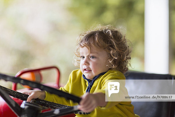 Caucasian baby boy driving tractor