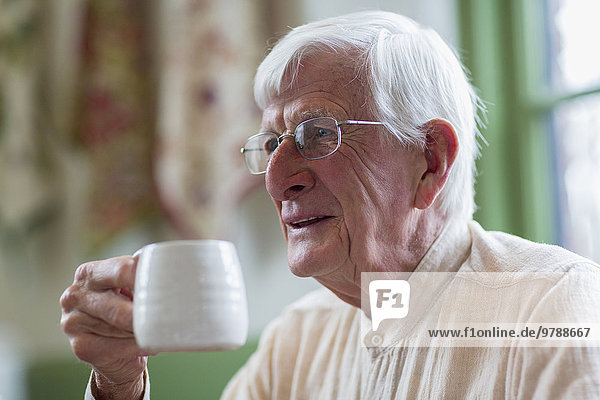 Older Caucasian man drinking coffee