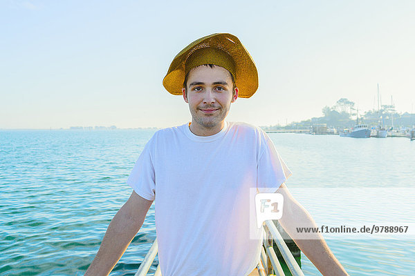 Caucasian man wearing sun hat on pier