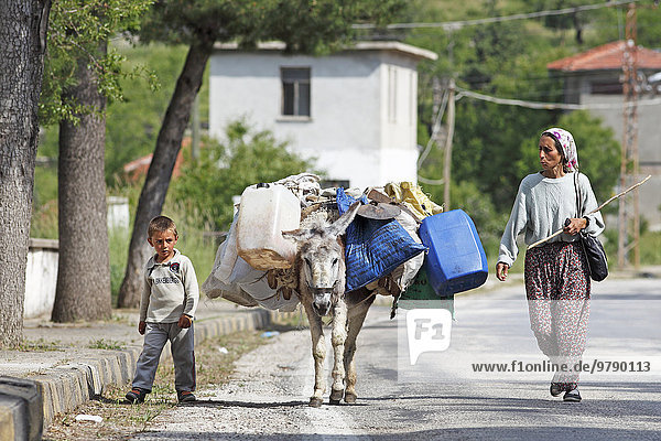 Frau und Junge mit Esel gehen eine Bergstraße entlang  Taurusgebirge  Provinz Konya  Türkei  Asien