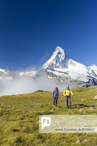 A woman and a man hiking on the Höhbalmen trail  the Matterhorn at the back  Zermatt  Canton of Valais  Switzerland  Europe