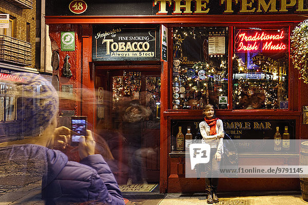 Man taking a photo of a woman in front of The Temple Bar  Dublin  Ireland  Europe