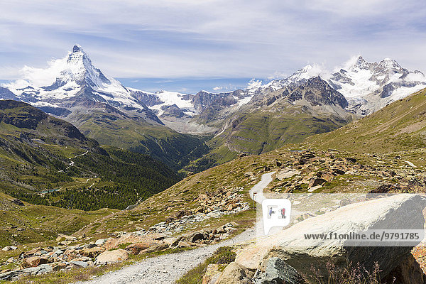 Two hikers on a trail to Stellisee lake  at the back the mountains Matterhorn  Dent Blanche  Obergabelhorn and Wellenkuppe  Zermatt  Canton of Valais  Switzerland  Europe