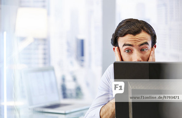Mann mit Computer im Büro  gestresst und beunruhigt.