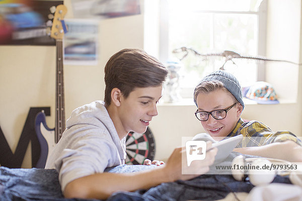 Zwei Teenager teilen sich ein digitales Tablett im Zimmer