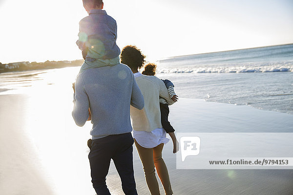Happy family walking on beach