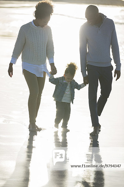 Happy family walking on beach