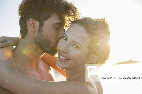 Portrait of smiling young couple in sunlight