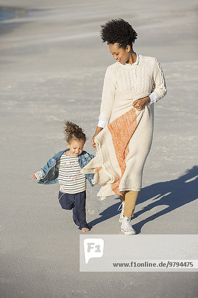 Mutter und Tochter beim Spaziergang am Strand