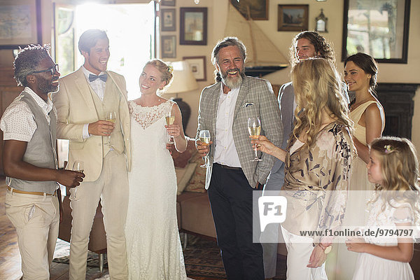 Young couple with guests and champagne flutes at wedding reception