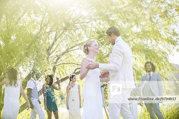 Young couple dancing at wedding reception in domestic garden