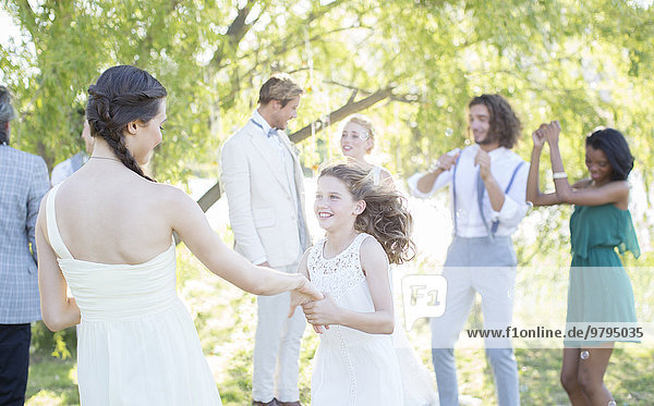 Brautjungfer und Mädchen tanzen bei der Hochzeitsfeier im Hausgarten