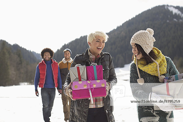 Freunde mit Weihnachtsgeschenken im Schnee