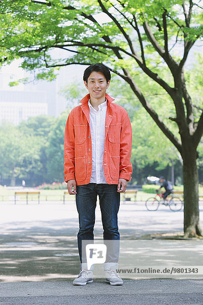 Young smiling Japanese man in a park